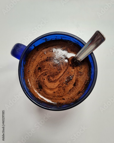 Fototapeta Naklejka Na Ścianę i Meble -  Blue glass coffee cup shot from above with a spoon