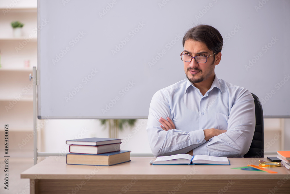 Young male teacher in front of whiteboard Young male teacher in front of whiteboard