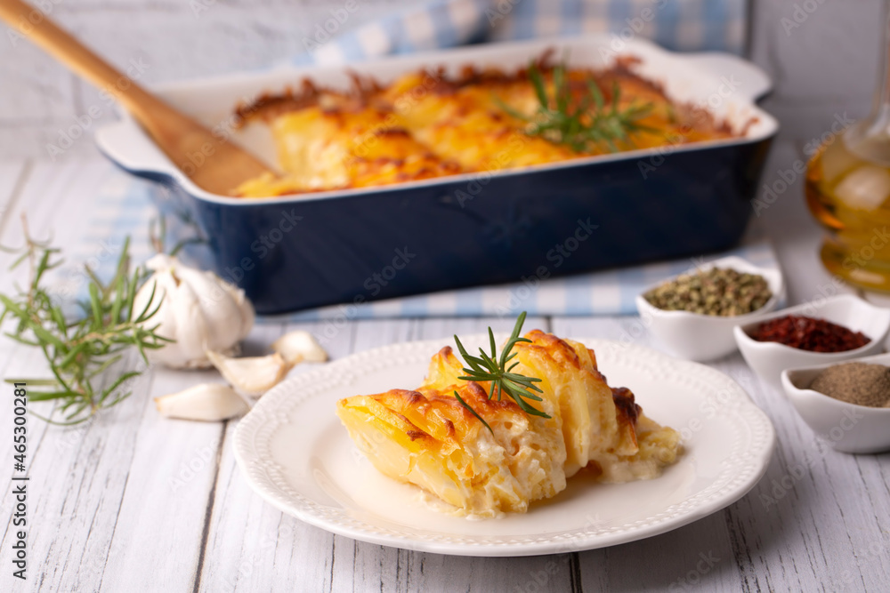 Potato gratin - graten (baked potatoes with cream and cheese) with rosemary and forks (Turkish name; Kremali patates) Potato gratin - graten (baked potatoes with cream and cheese) with rosemary and forks (Turkish name; Kremali patates)