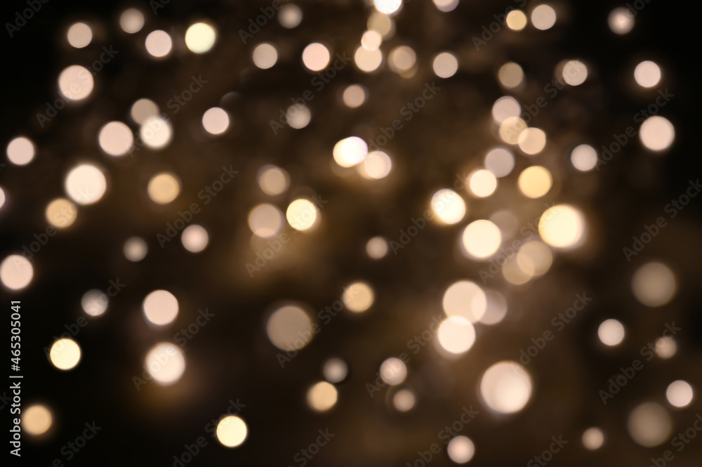 Beautiful golden defocused lights on brown background. Holiday decoration. Beautiful golden defocused lights on brown background. Holiday decoration.