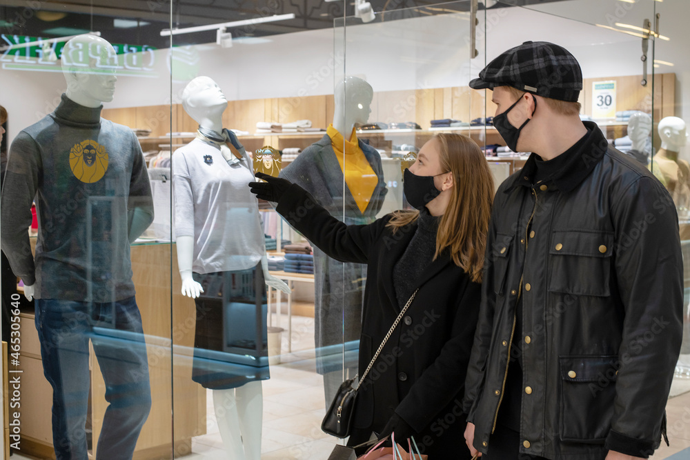 Black friday pandemic concept. Young couple in black masks at the mall Black friday pandemic concept. Young couple in black masks at the mall