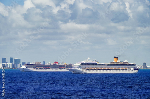 Modern Carnival and Costa cruiseships cruise ship liners at sea with Miami South Beach skyline in background on summer day photo