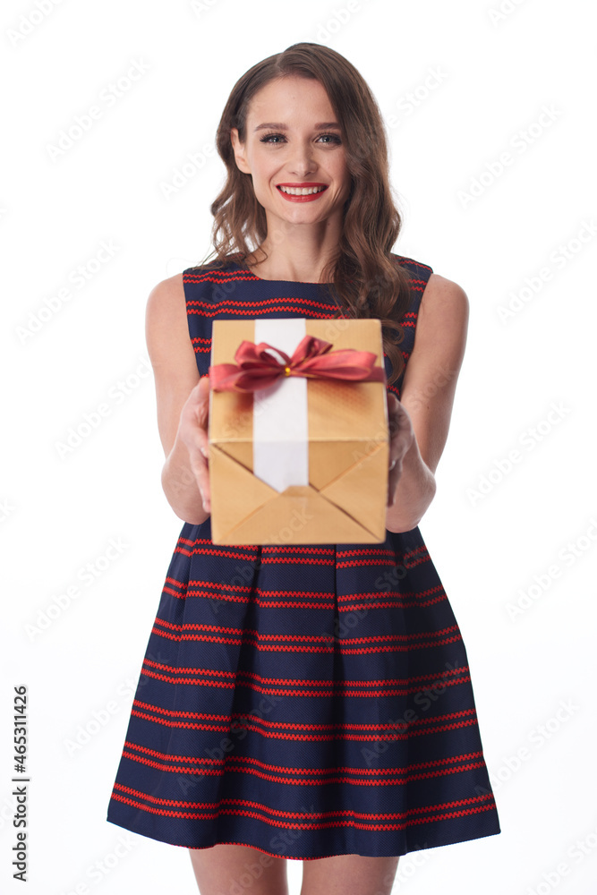 Portrait of positive young Caucasian woman in stripped dress giving gift box to you, white background Portrait of positive young Caucasian woman in stripped dress giving gift box to you, white background