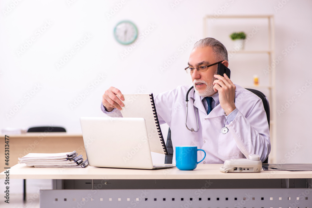 Aged male doctor working in the clinic Aged male doctor working in the clinic