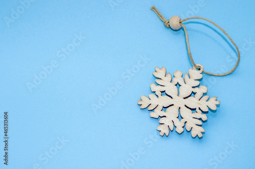 toy,snowflakechristmas decor, christmas banner with free space for text,mockup.wooden showflake shape isolated on light blue background. happy new year, festive styled stock image,top view,minimalism photo