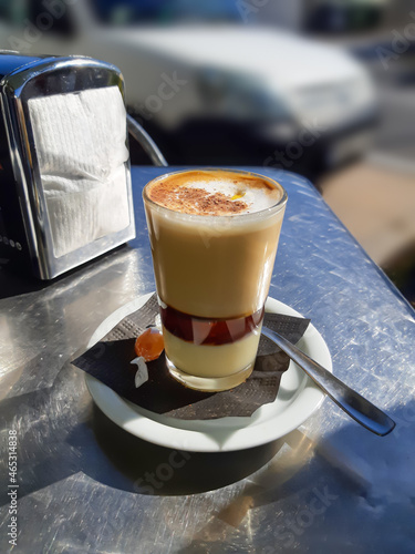 A cup of four-layer coffee on a table in a roadside cafe