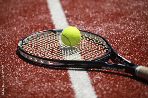 Tennis racket and tennis ball on sport court © BillionPhotos.com