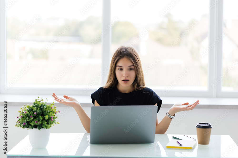 Shocked young woman looking at laptop screen. Shocked young woman looking at laptop screen.