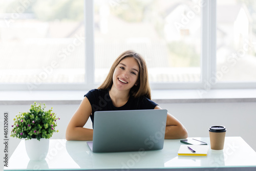 Free Download Portrait of a young businesswoman using laptop in office - GFXLoad