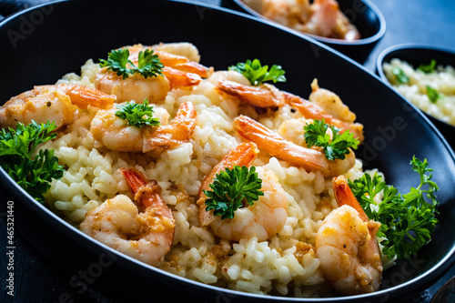 Risotto with prawns  chili and parsley on wooden table  