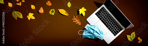 Laptop computer with masks in autumn - overhead view photo