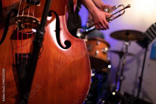 A good looking acoustic double bass captured from a live performance gig in a bar with a trumpet player in the background