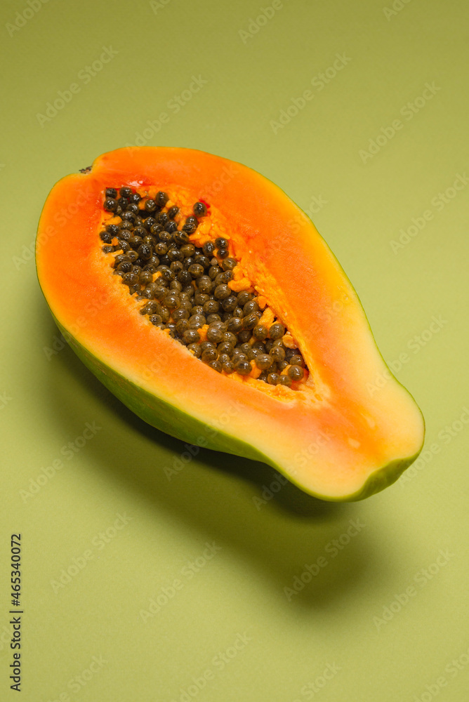 Papaya fruit on a green background. Half papaya. Papaya fruit on a green background. Half papaya.