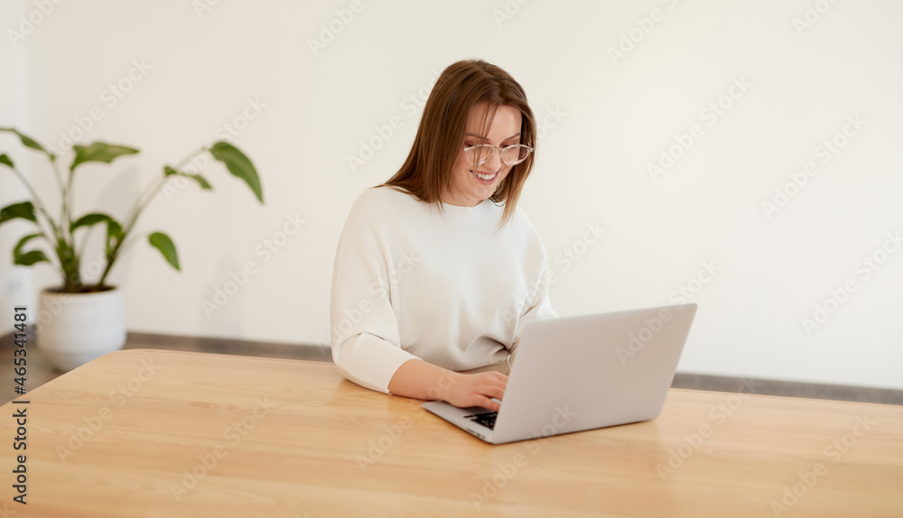 Woman working on laptop in minimalist workspace Woman working on laptop in minimalist workspace