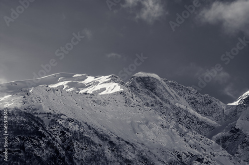 Black and white snowy sunlight mountains, view from off piste slope © BSANI