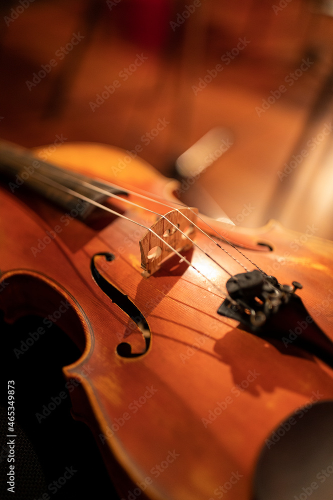 Fototapeta premium A violin or a viola on a black chair. A classical string instrument common to symphony orchestra.
