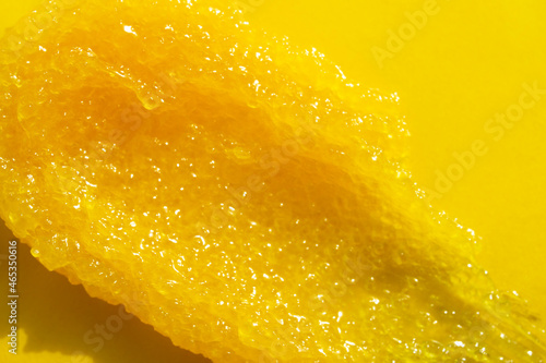 Yellow scrub closeup texture. Organic beauty exfoliating cosmetic. Natural smudged peeling. Skin care salt, sugar treatment