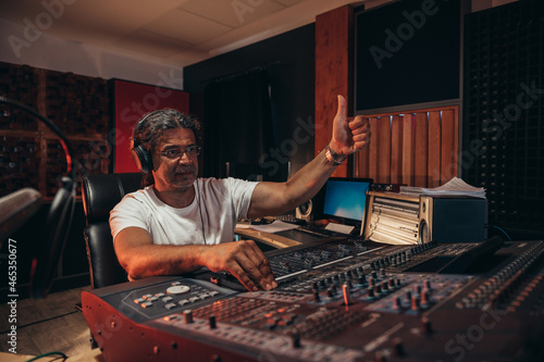Принти на полотні Senior hispanic music producer working on a mixing soundboard while in his studi