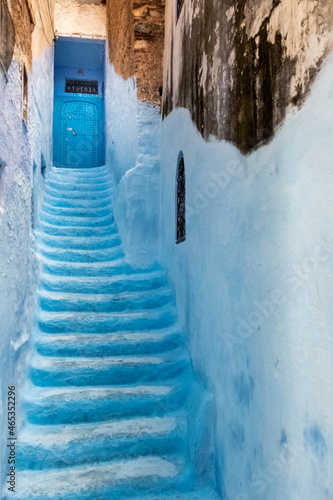 In the medina of Chefchaouen in Morocco. A narrow staircase painted in blue climbs between 2 walls to a closed blue door © Louis-Michel DESERT