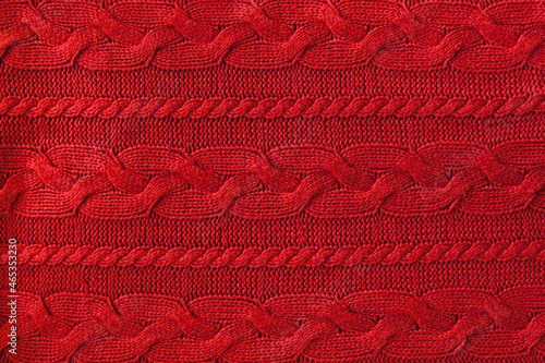 Knitted woolen background, red texture. Knitted fabric.