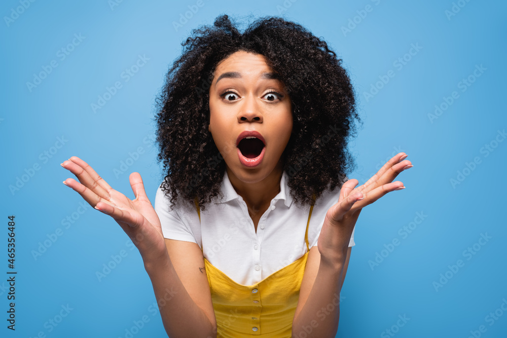 amazed african american woman with open mouth showing wow gesture isolated on blue - obrazy, fototapety, plakaty 