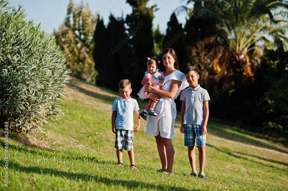 Mother with three kids on Turkey resort against palms. Mother with three kids on Turkey resort against palms.