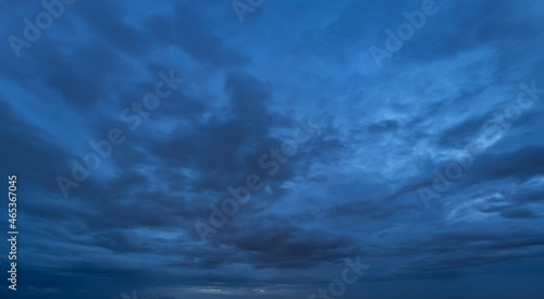 Dramatic dark blue clouds sky with thunder storm and rain at night. Abstract nature landscape background.