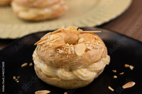 Traditional and classic dessert Paris Brest on black plate