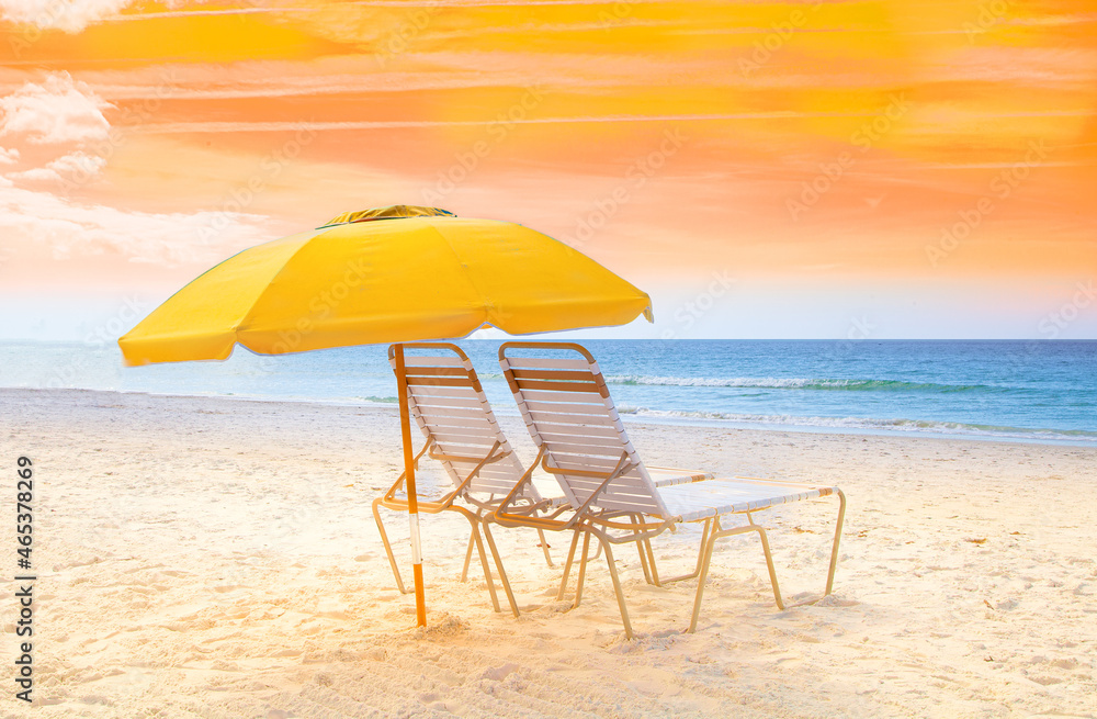 Beach chairs with umbrella at the ocean with yellow sky