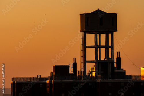 Urban water tower at sunset (golden hour) in Brooklyn, New York.