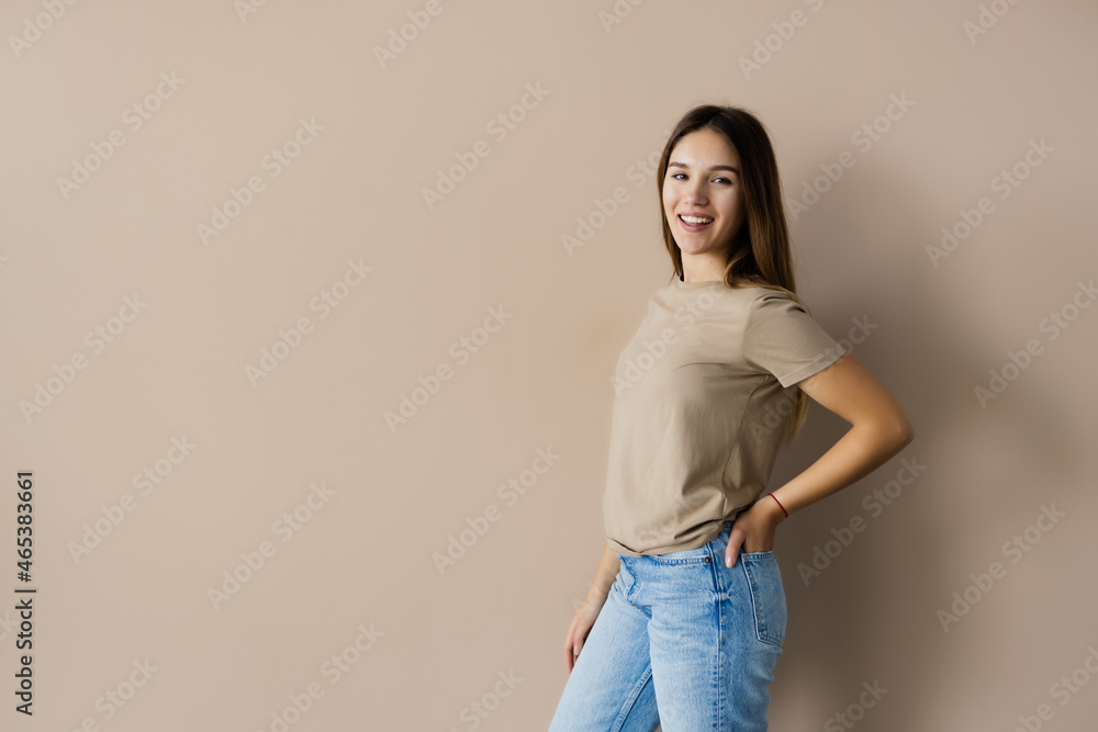 Portrait of a smiling young woman posing isolated over beige background Portrait of a smiling young woman posing isolated over beige background