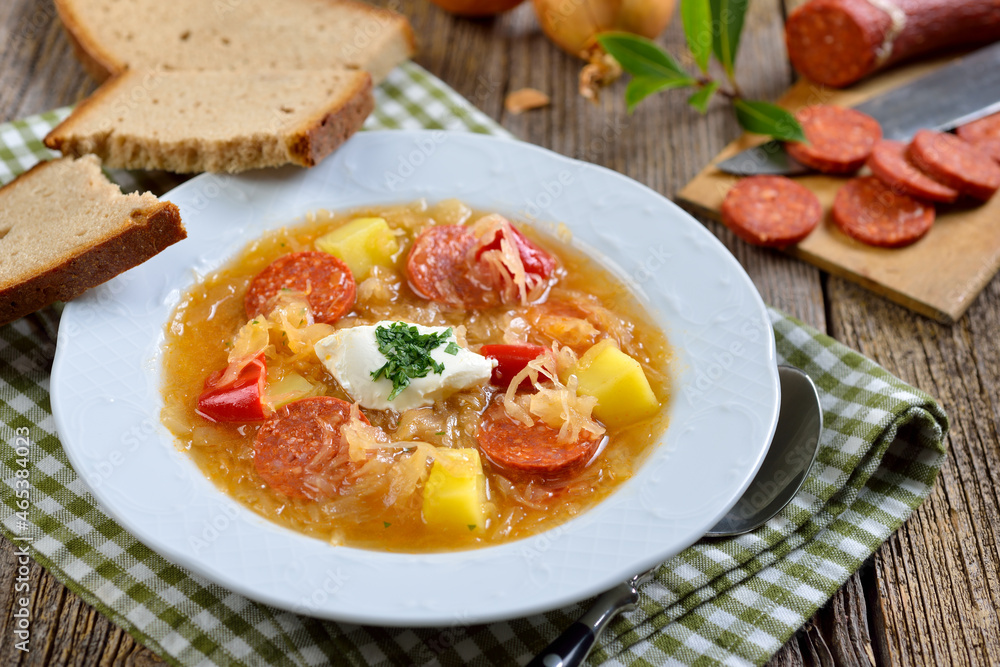 Kräftige Sauerkrautsuppe mit pikanter Paprikawurst, serviert mit leckerem Bauernbrot – Delicious German sauerkraut soup with slices of spicy paprika sausage, served with farmers bread Kräftige Sauerkrautsuppe mit pikanter Paprikawurst, serviert mit leckerem Bauernbrot – Delicious German sauerkraut soup with slices of spicy paprika sausage, served with farmers bread