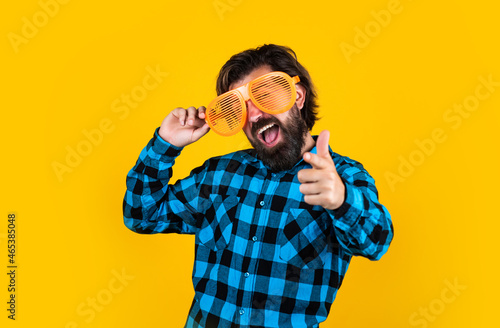 bearded man in checkered shirt and party glasses. funny guy express human emotions. happy hipster with long hair and moustache having fun. male is going on summer vacation