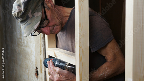 The worker screws the screw with a screwdriver