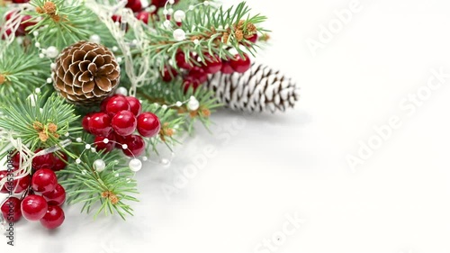 Decorating white background for Christmas with fir twigs, cones and berries. Stop motion