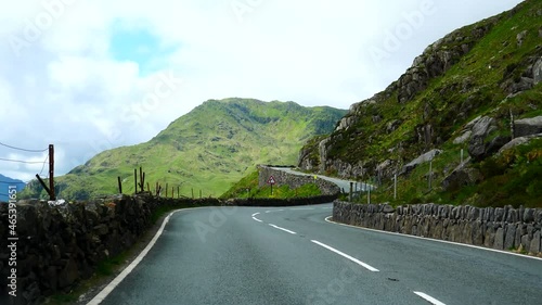Car windscreen view driving winding road A4086 in Snowdonia National Park mountains towards Pen y Pass in Wales, United Kingdom. photo