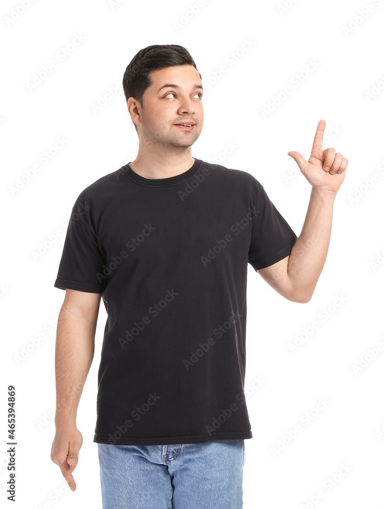 Handsome young man in stylish t-shirt pointing at something on white background Handsome young man in stylish t-shirt pointing at something on white background