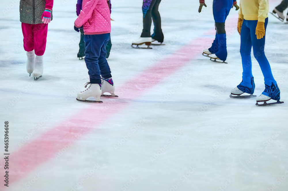 Skates on the ice of the ice arena. A group of young girls at the training session of the figure skating sports section. Skates on the ice of the ice arena. A group of young girls at the training session of the figure skating sports section.