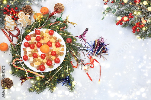 Christmas new year dishes, traditional holiday salad of cheese, tangerines, grapes and honey, for vegan food, fir branches and cones and decorations, food design idea, place for recipe, flat lay, photo