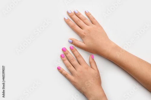 Female hands with stylish different color manicure on white background