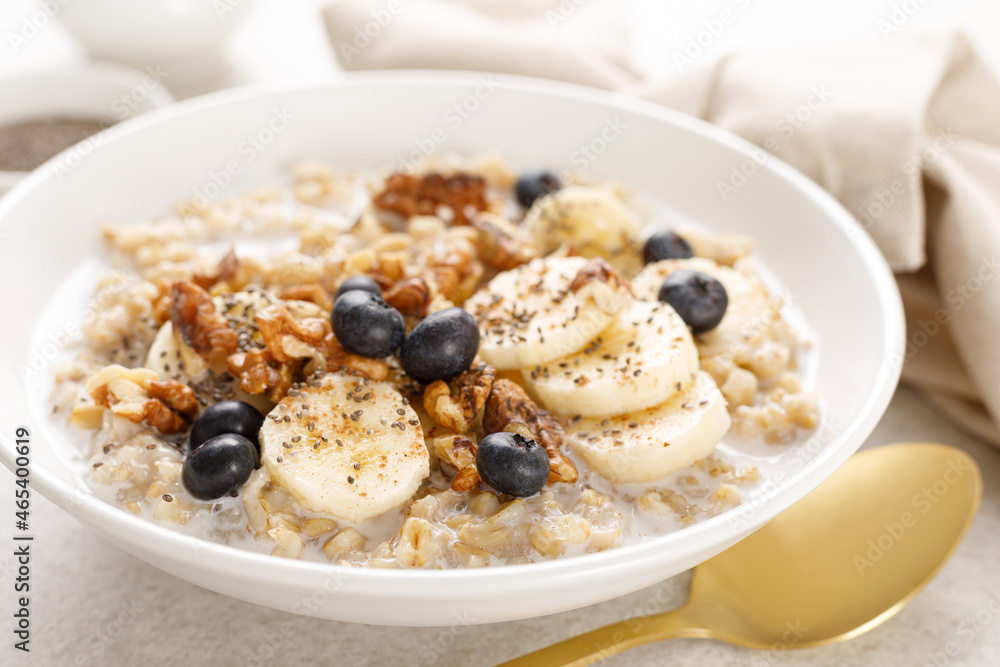 Oatmeal bowl. Oat porridge with banana, blueberry, walnut, chia seeds and almond milk for healthy breakfast or lunch. Healthy food, diet. Oatmeal bowl. Oat porridge with banana, blueberry, walnut, chia seeds and almond milk for healthy breakfast or lunch. Healthy food, diet.
