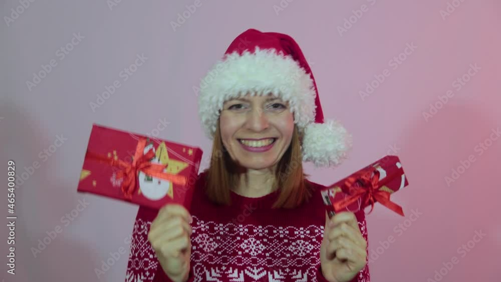 Happy female in red santa hat holding boxes with gifts. Happy female in red santa hat holding boxes with gifts.