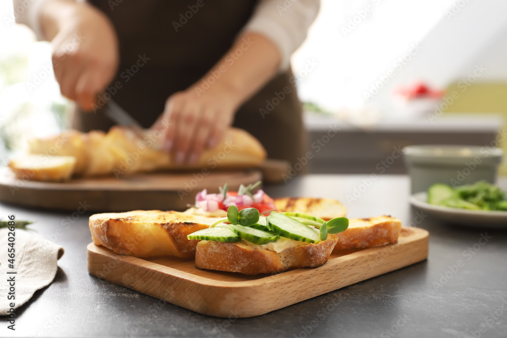 Board with tasty vegetarian bruschettas on table in kitchen, closeup