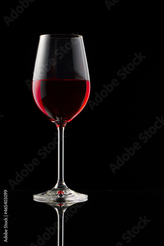 A glass of red wine on a glossy table.