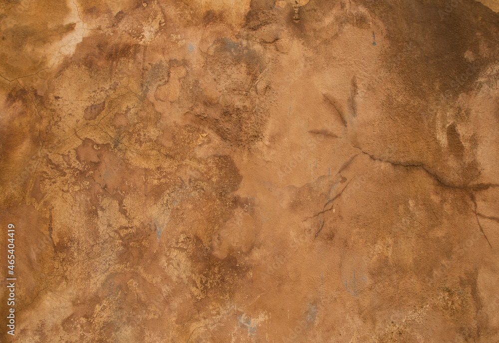 Yellow brown plaster stucco wall in a warm sunny day. An abstract background photo. Yellow brown plaster stucco wall in a warm sunny day. An abstract background photo.
