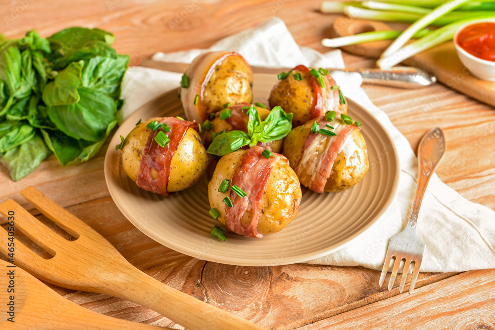 Plate of tasty baked potatoes with bacon on wooden background Plate of tasty baked potatoes with bacon on wooden background