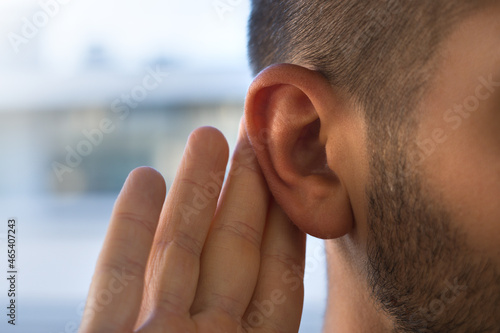 Young man with hearing problems, hearing loss or hard of hearing photo