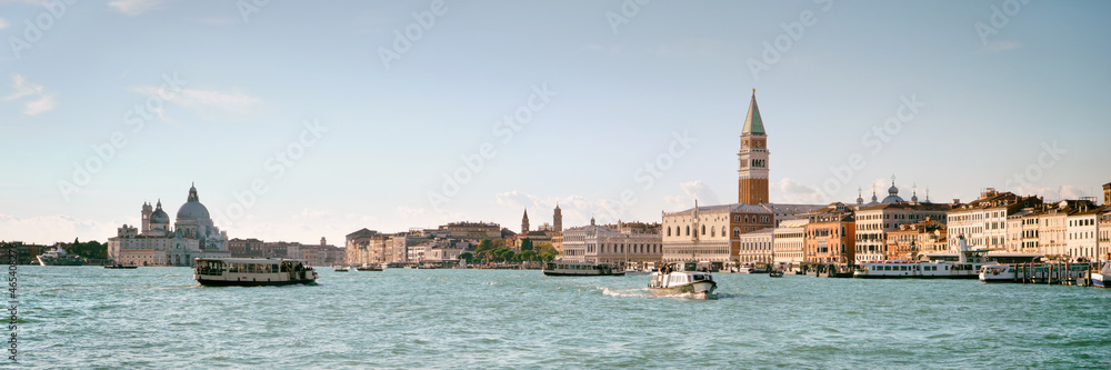 Italy, Venice, panoramic image of Riva degli Schiavoni, the Venice Promenade, with passenger boats. City skyline banner. Church Santa Maria della Salute, Doge's palace and St Mark's Campanile tower.
