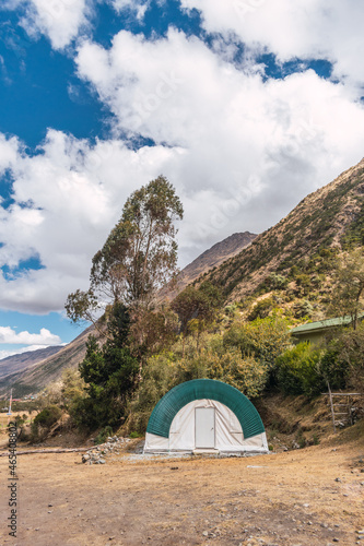 camping in the Andes mountain range outdoor camping tents on a sunny day with clouds and a blue sky surrounded by green vegetation