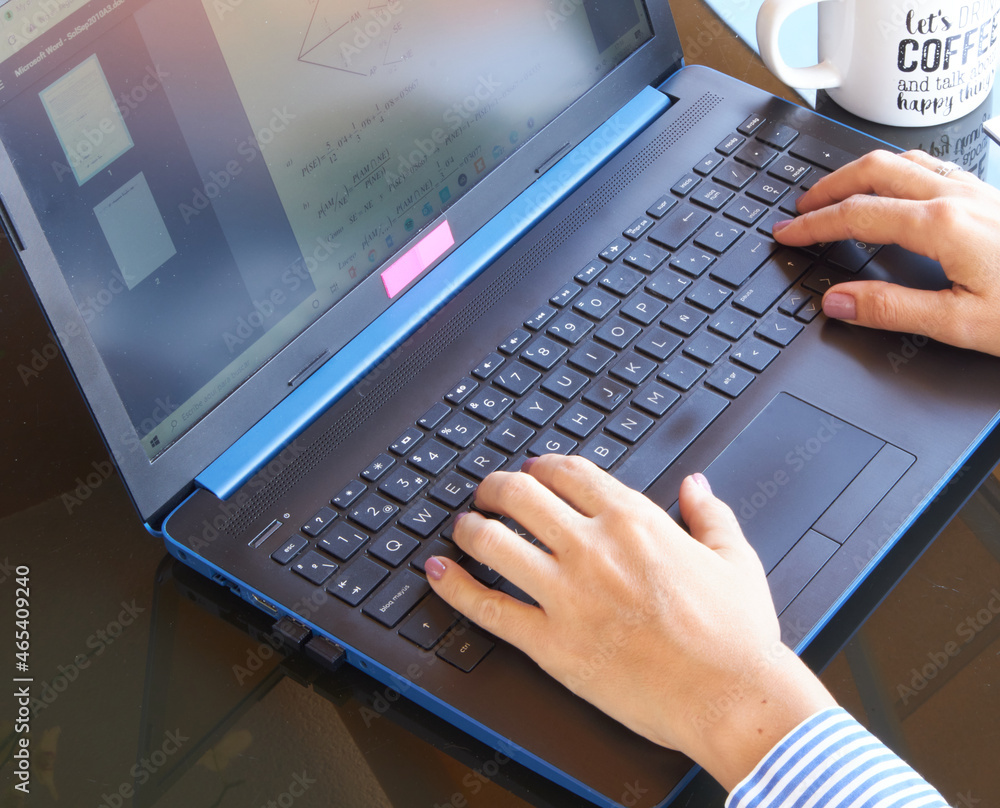 WOMAN WORKING ON LAPTOP COMPUTER AT HOME AND DRINKING COFFEE, REMOTE WORK, THE BALANCE OF FAMILY AND WORK LIFE IS VITAL WOMAN WORKING ON LAPTOP COMPUTER AT HOME AND DRINKING COFFEE, REMOTE WORK, THE BALANCE OF FAMILY AND WORK LIFE IS VITAL